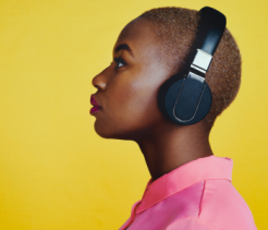 Woman wearing big headphones on a yellow background